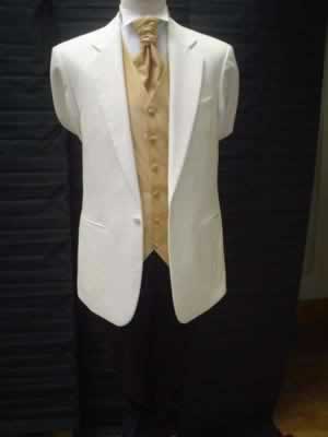 Cream jacket with black trousers and gold waistcoat