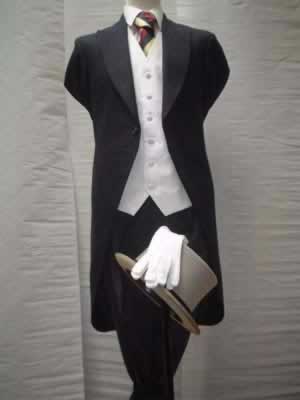 Navy tails with stripe trousers, white waistcoat and gold and red stripe tie