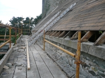 Relaying masonry and coping stones along top of nave south wall