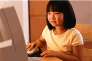Girl happily using computer in e-learning.