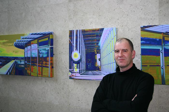 Vincent Cahill beside three of his canvas photographs commissioned by The Quinn Group for their landmark offices in the Blanchardstown Centre.