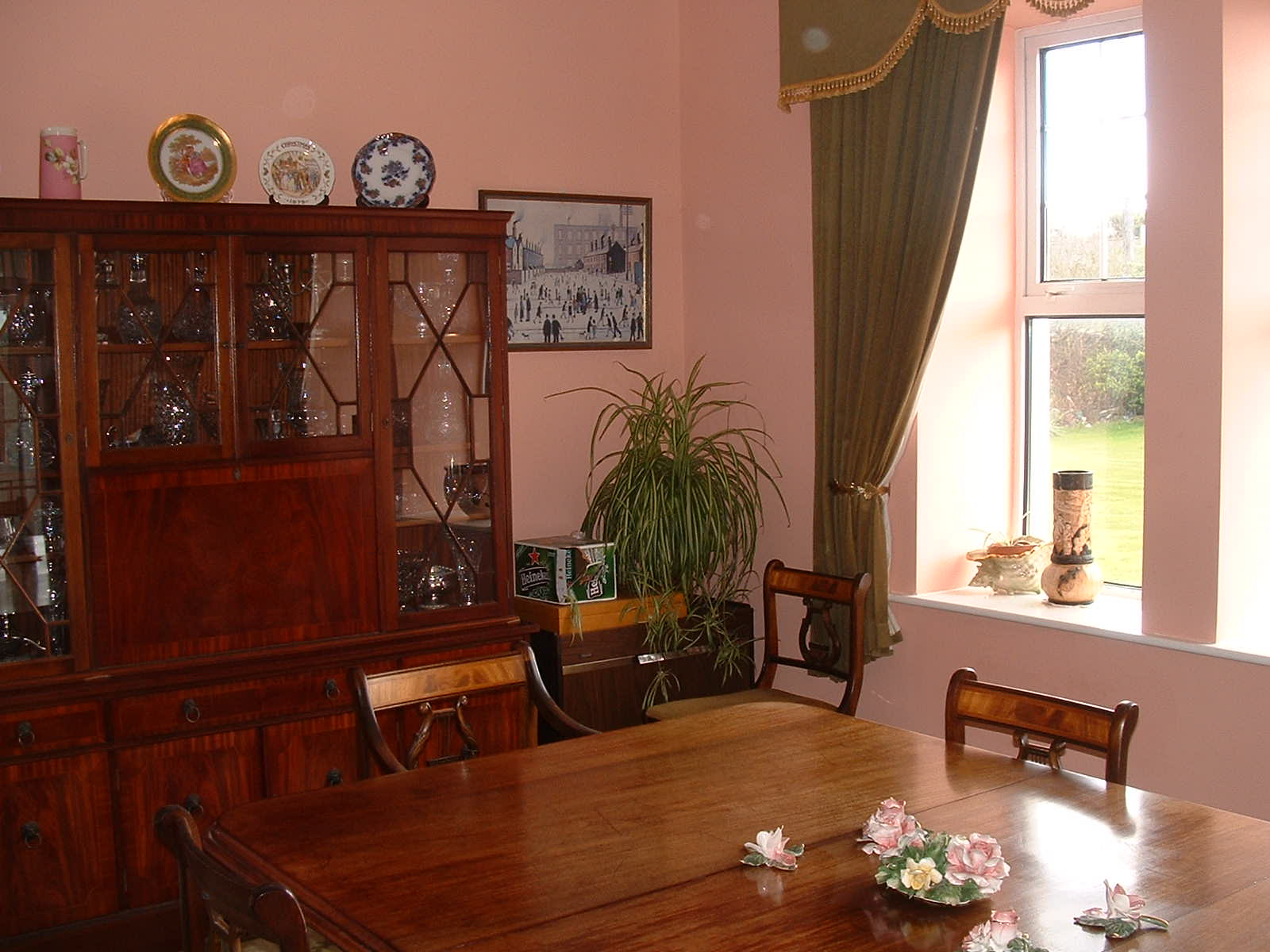 The dining room featuring a fine polished wood cabinet, table and chairs